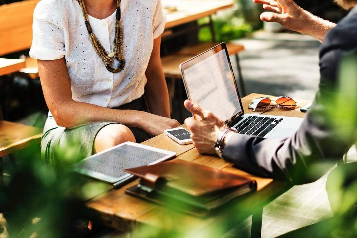 business people sitting outside with laptop