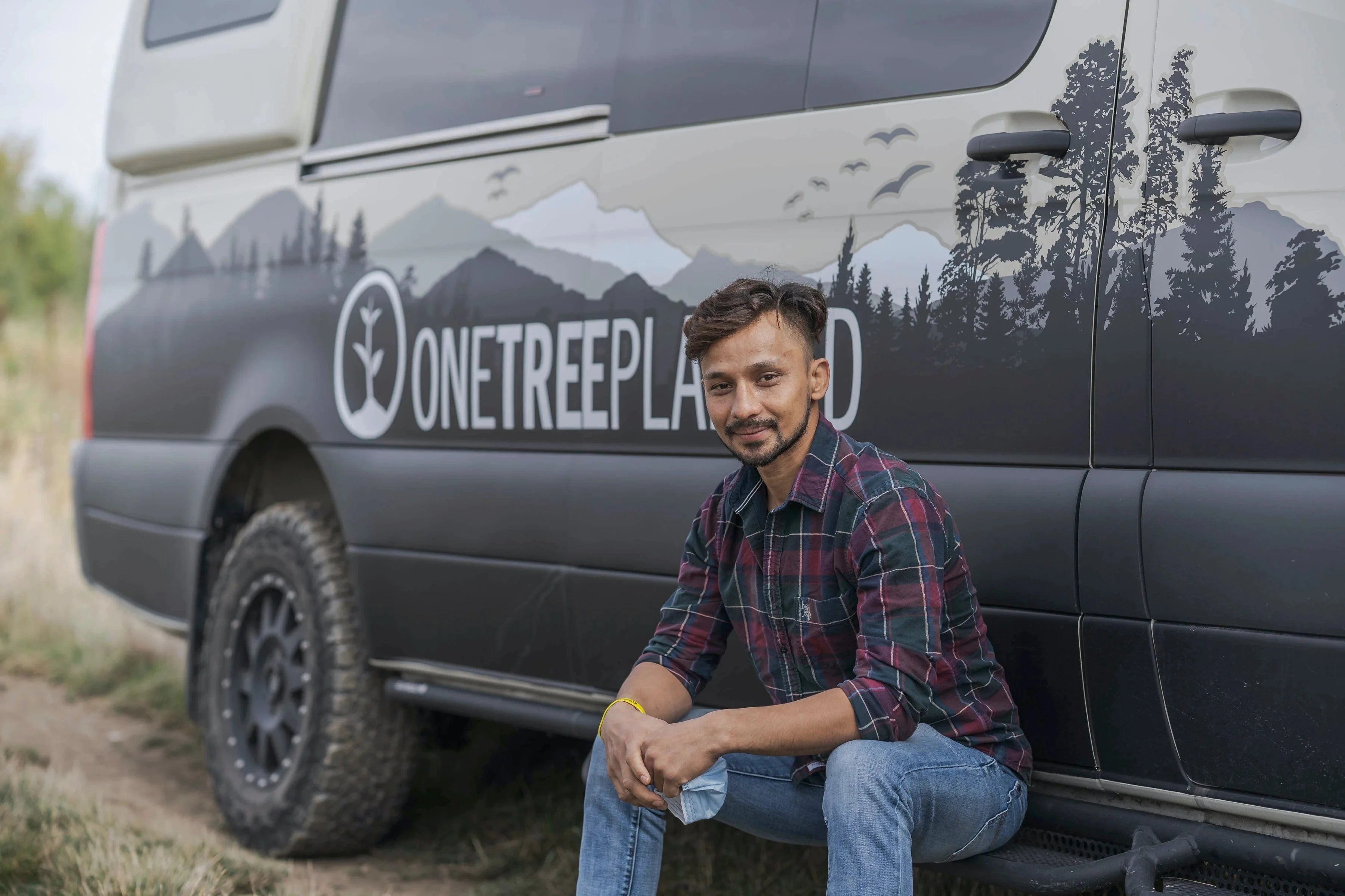 Toronto-CA community volunteer sitting in front of one tree planted van plant a tree day