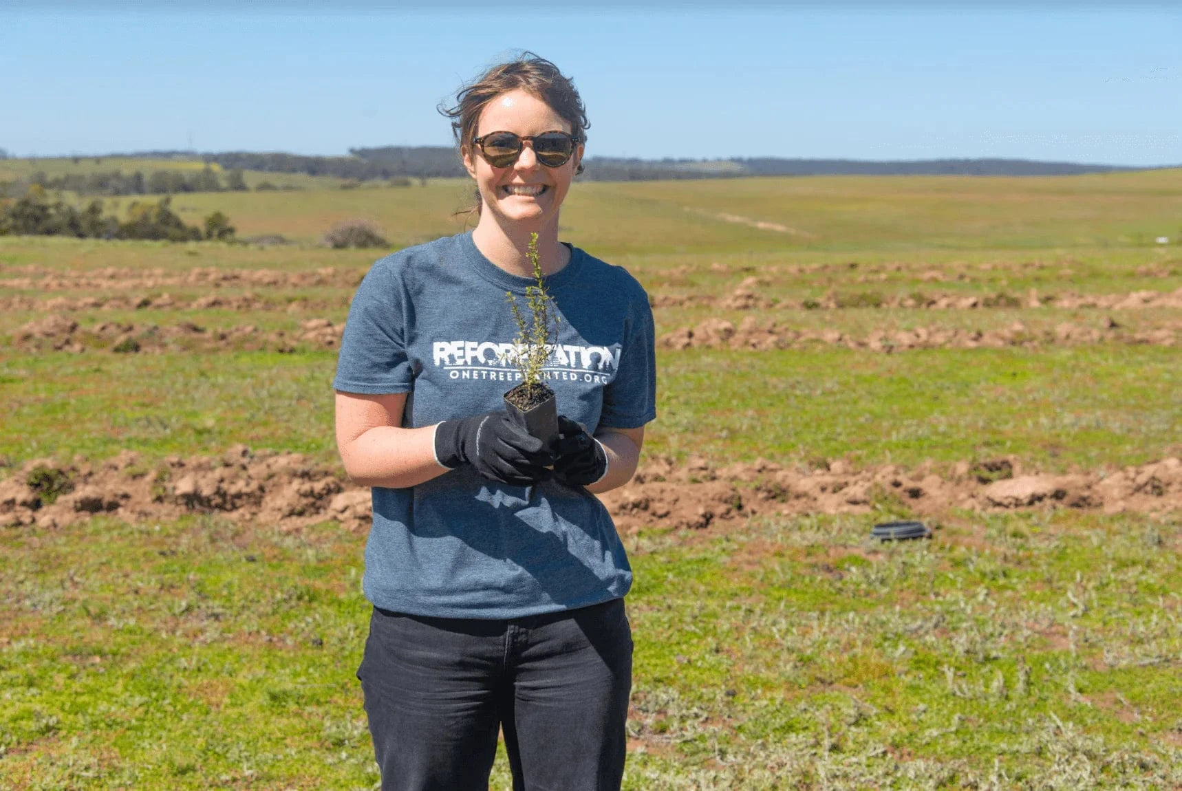 beth from one tree planted holding a seedling