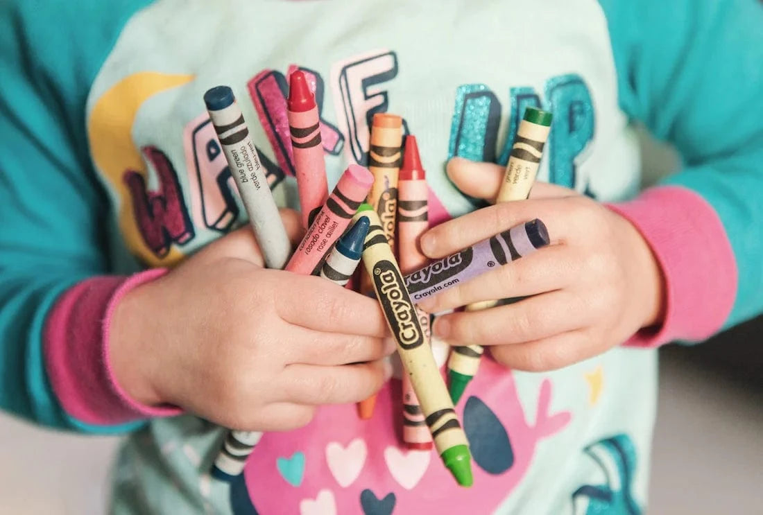 kid holding crayons