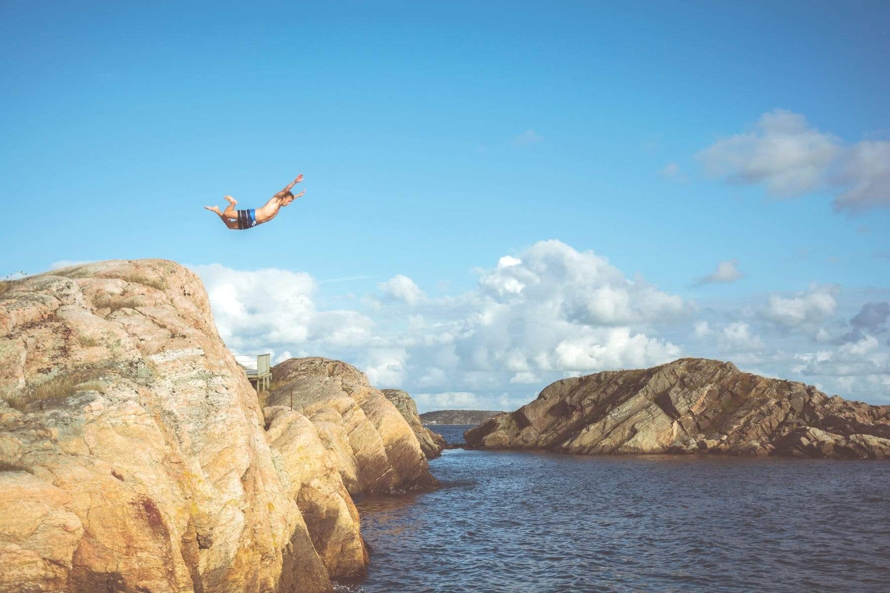 Man leaps off cliff into water