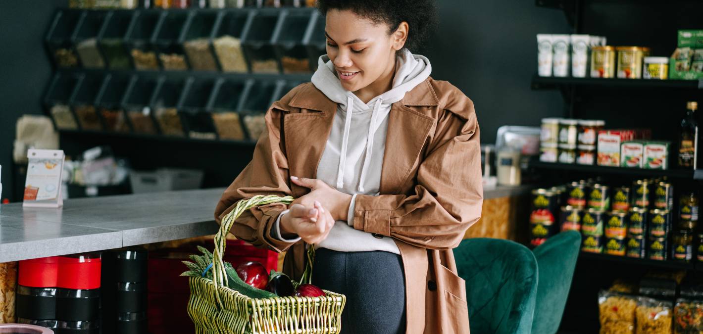 woman shopping at grocery store with bulk bins