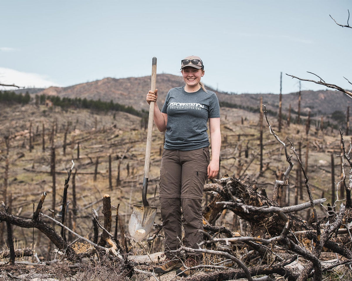 Volunteer wearing Reforestation T-shirt while planting trees