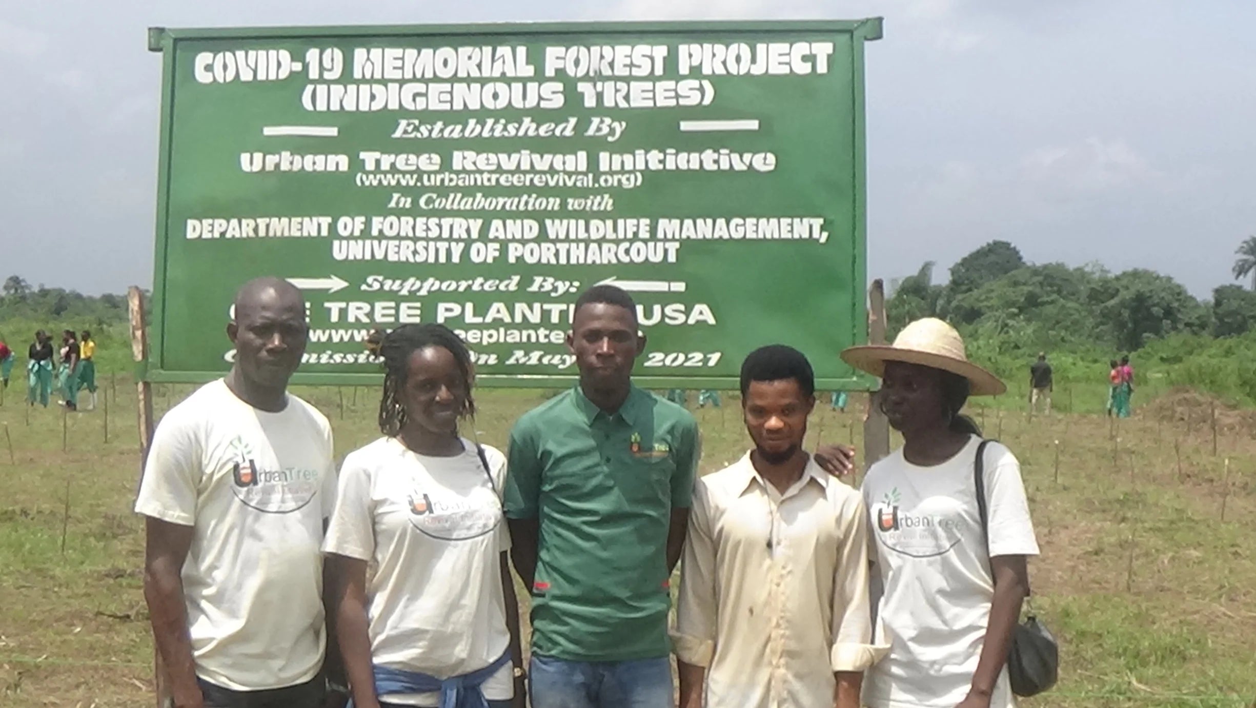 people standing in front of a sign in Nigeria 