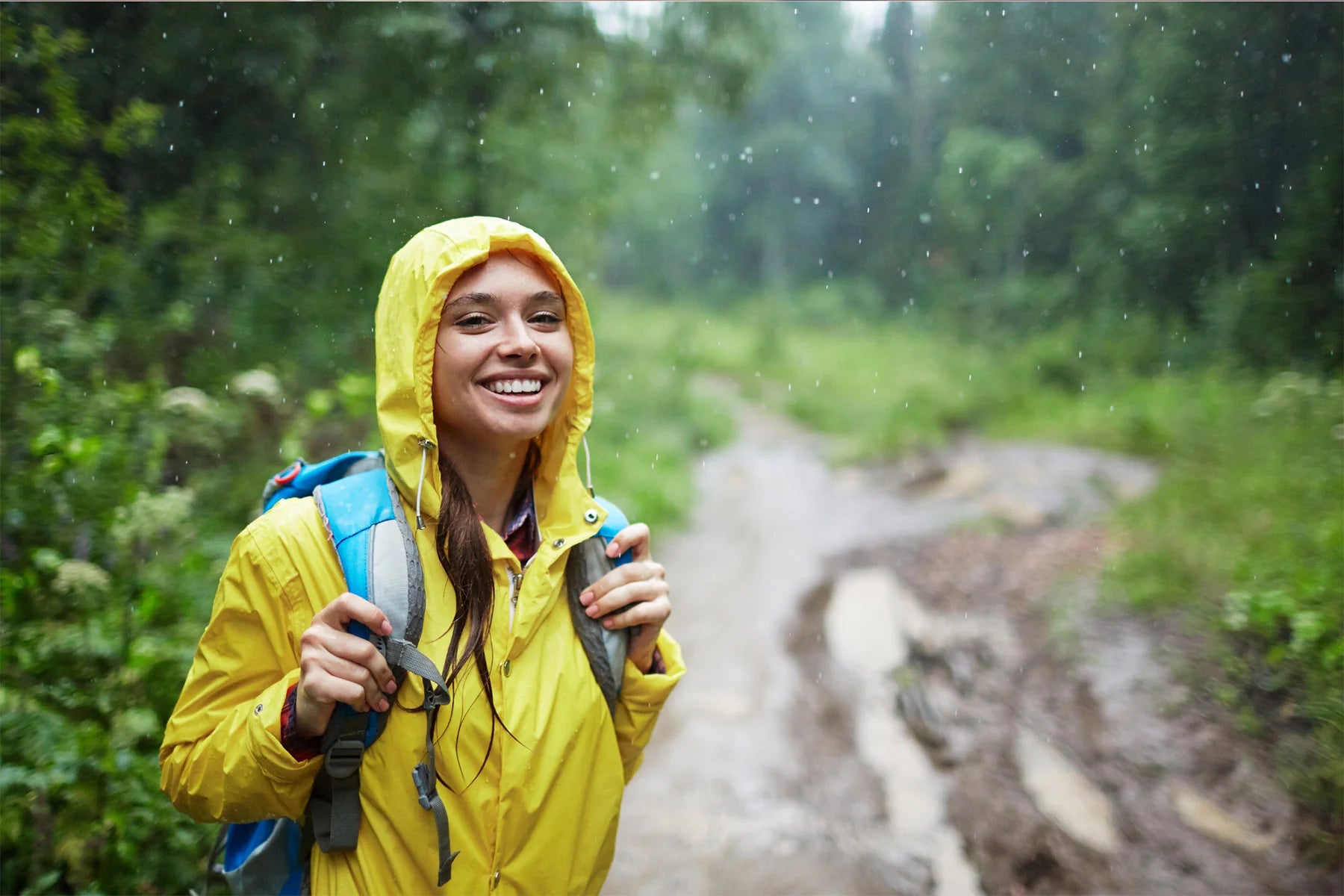 woman smiling rain coat forest